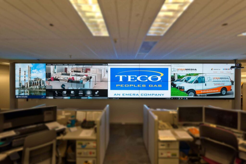 TECO branding displayed on large AV screens at The ProMedia Group event setup.