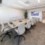 0T1A6860-HDR Modern conference room with white chairs and large screen display for meetings.