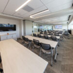 0T1A6878-HDR Modern corporate training room with rows of chairs and presentation screens for professional events.