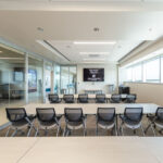 0T1A6887-HDR Modern conference room with glass walls and a large screen for presentations and meetings.